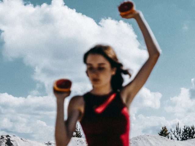 a woman holding two oranges in her hands